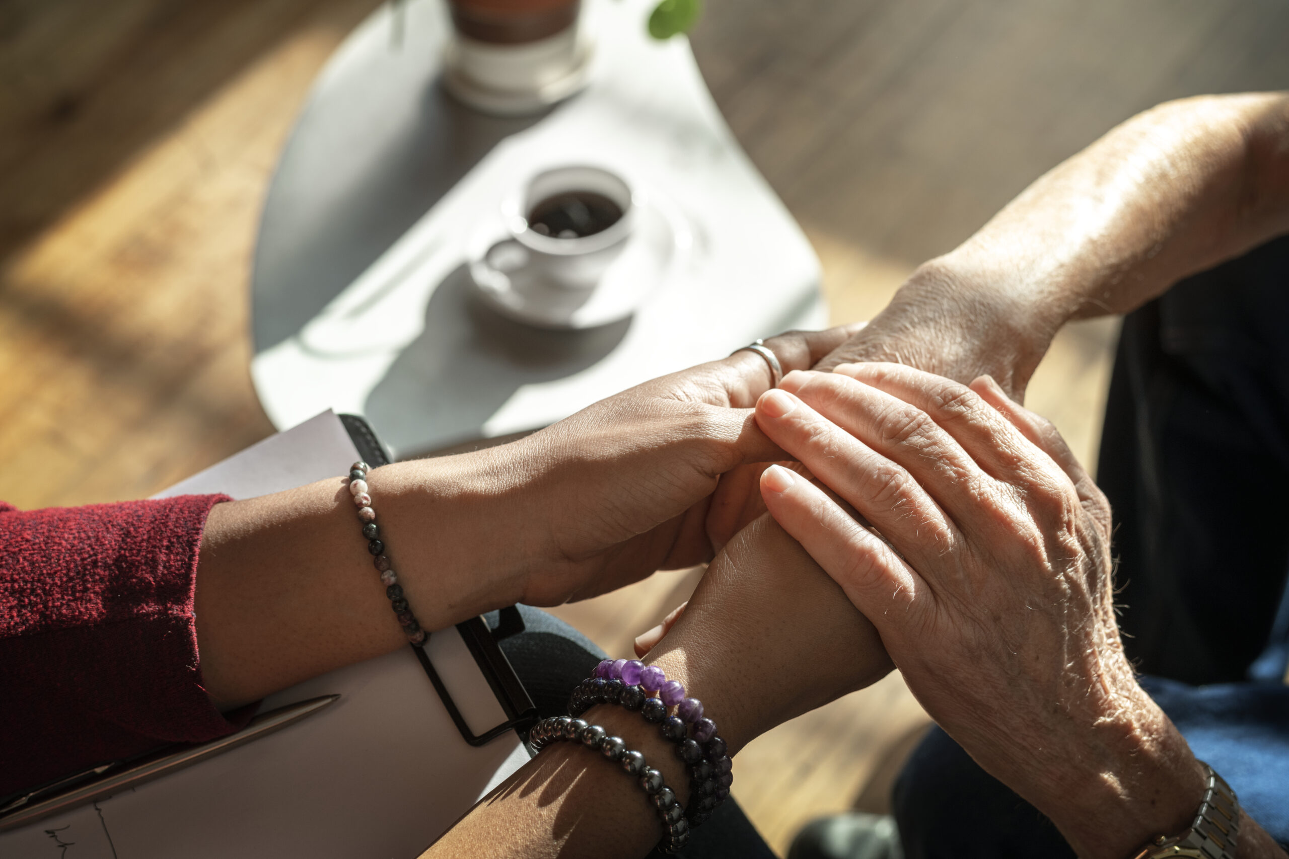 Female psychologist holding elderly patient&#039;s hands